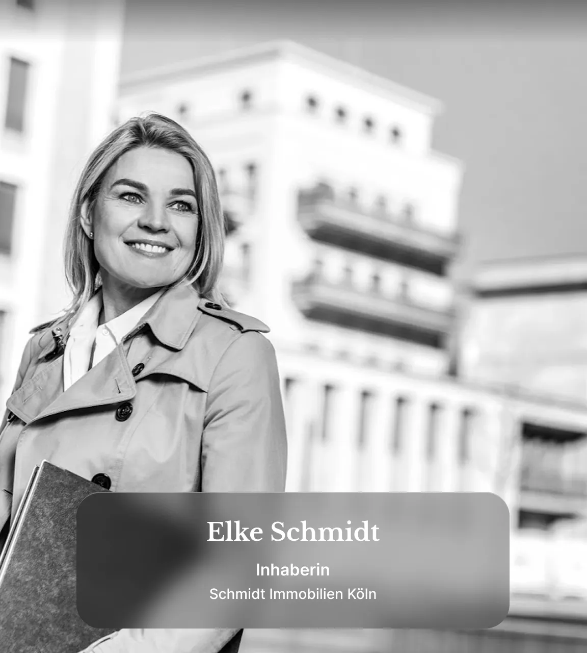 Immobilienmakler Köln: Porträt einer lächelnden Immobilienmaklerin vor urbaner Kulisse mit modernen Wohngebäuden im Hintergrund.